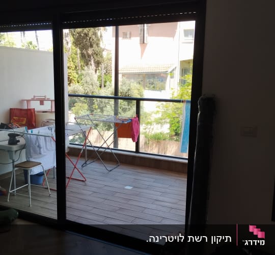 תריסים סגורים מעל דלת זכוכית במרפסת